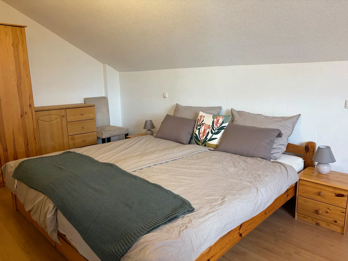 Ferienwohnung Kempten – Schlafzimmer mit massivem Holzbett und Allgäuer Stoffen